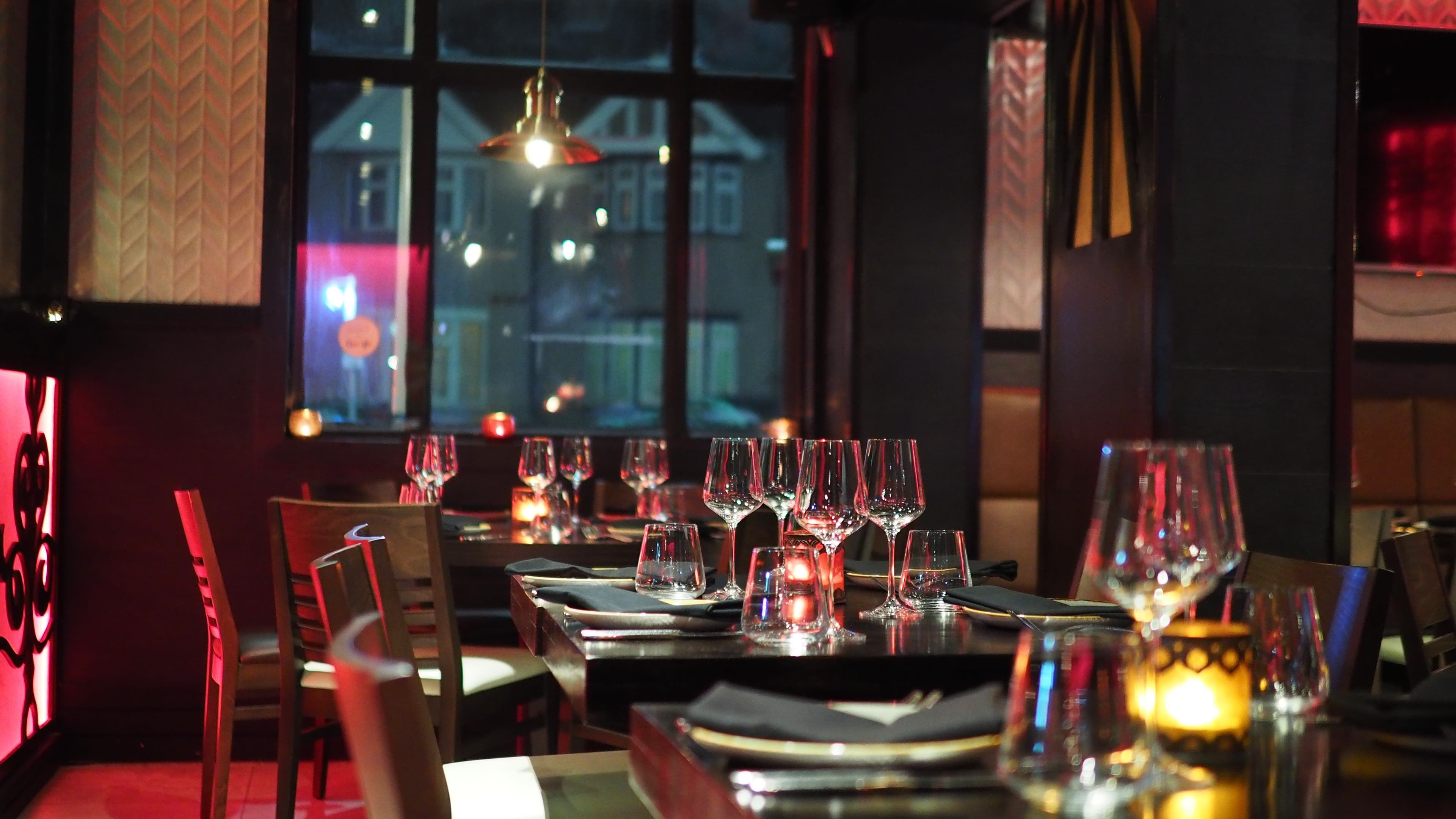An elegant restaurant lit by candlelight in the evening.